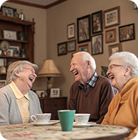 three older people laughing at a table