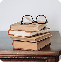 glasses lying on a pile of old books